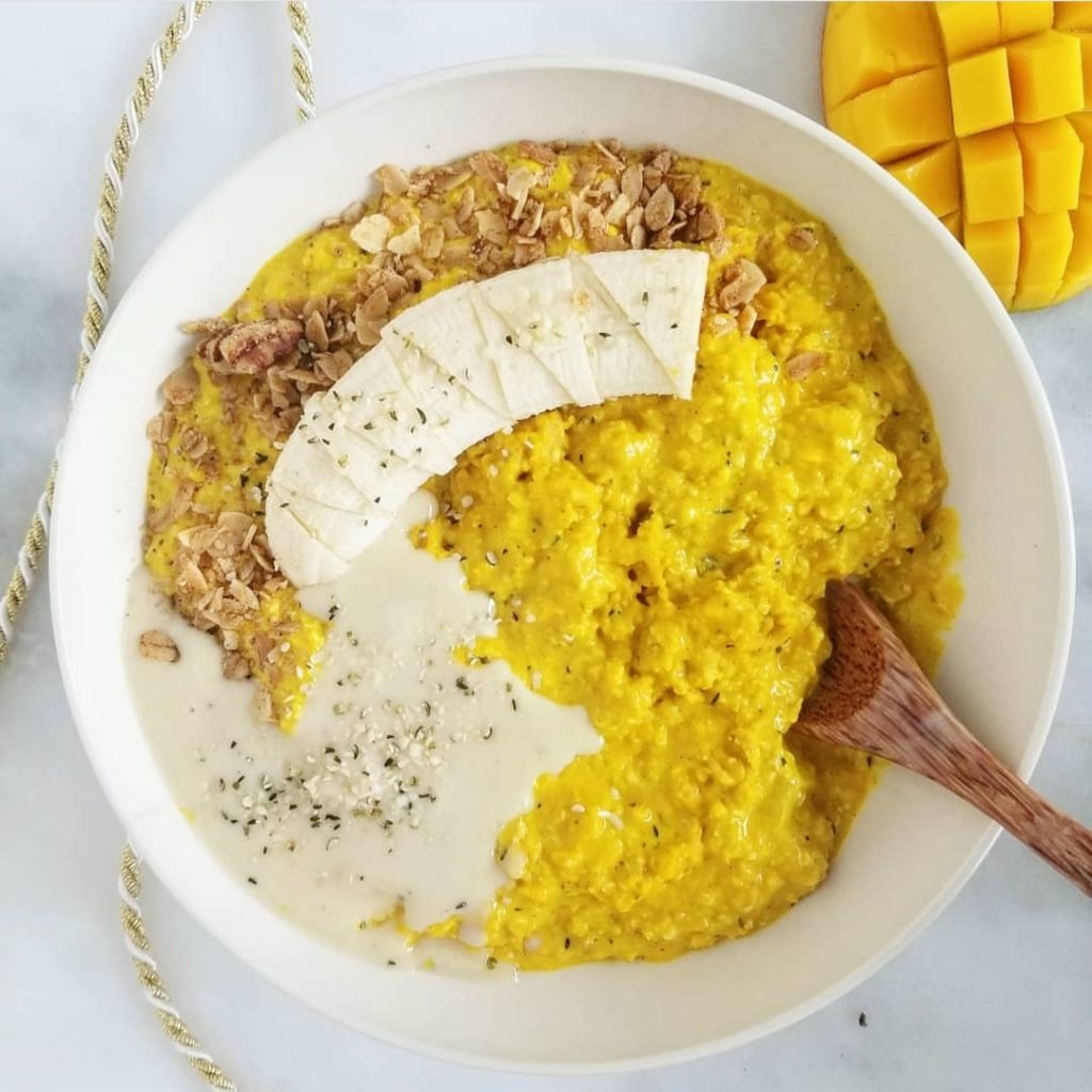 golden oats topped with a banana, nut butter, granola, and hemp seeds