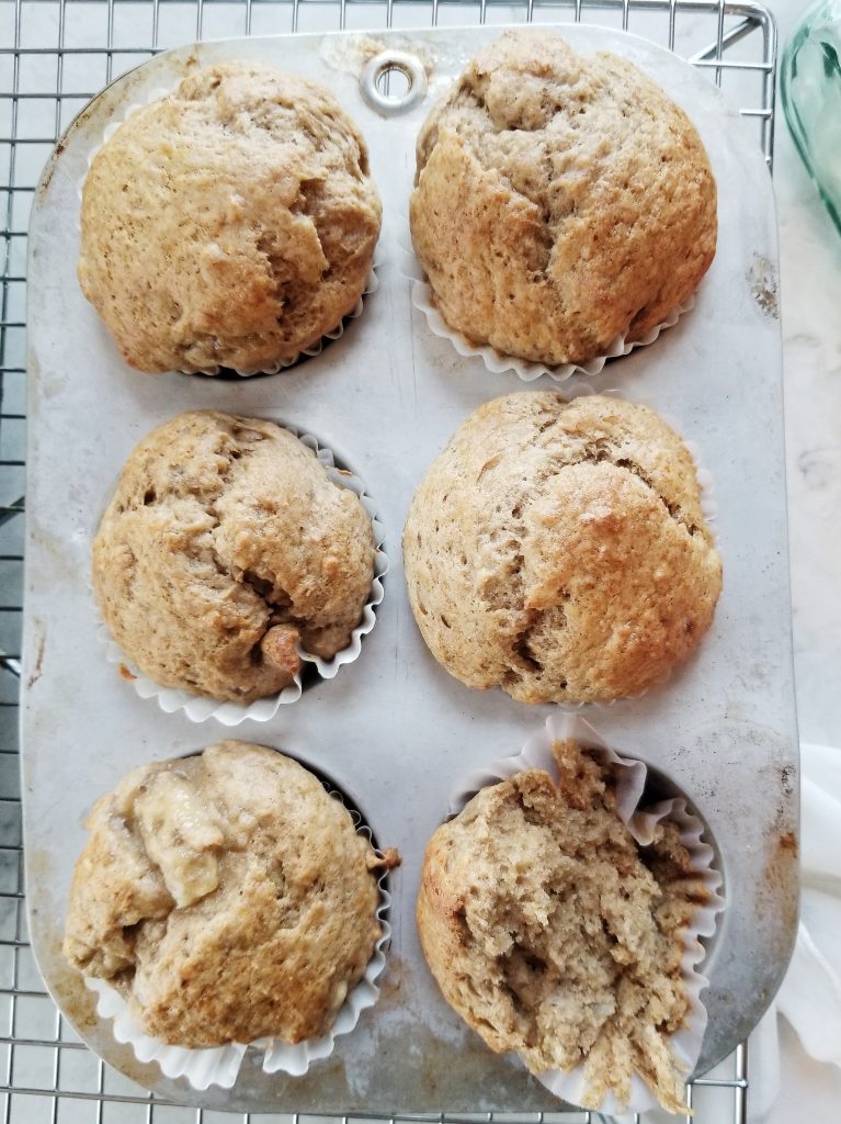 classic dairy free banana muffins in a muffin tray on a cooling rack 