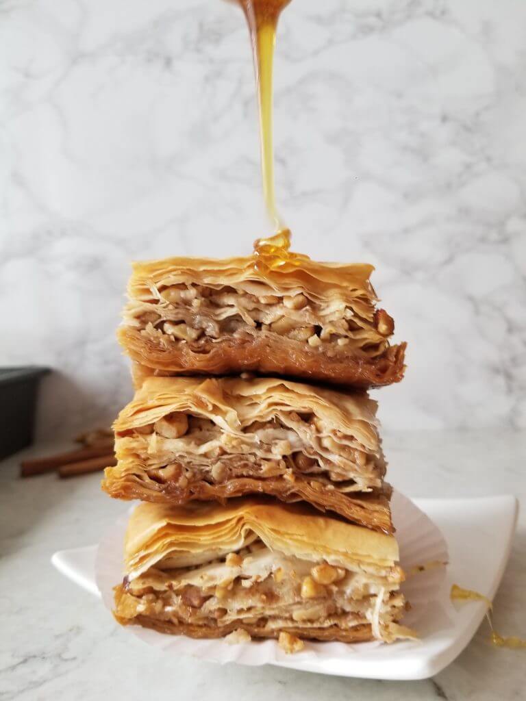 drizzling honey over the pieces of walnut baklava