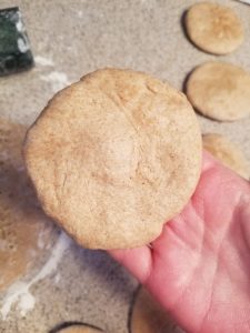 whole wheat naan dough shaped into a small disk 