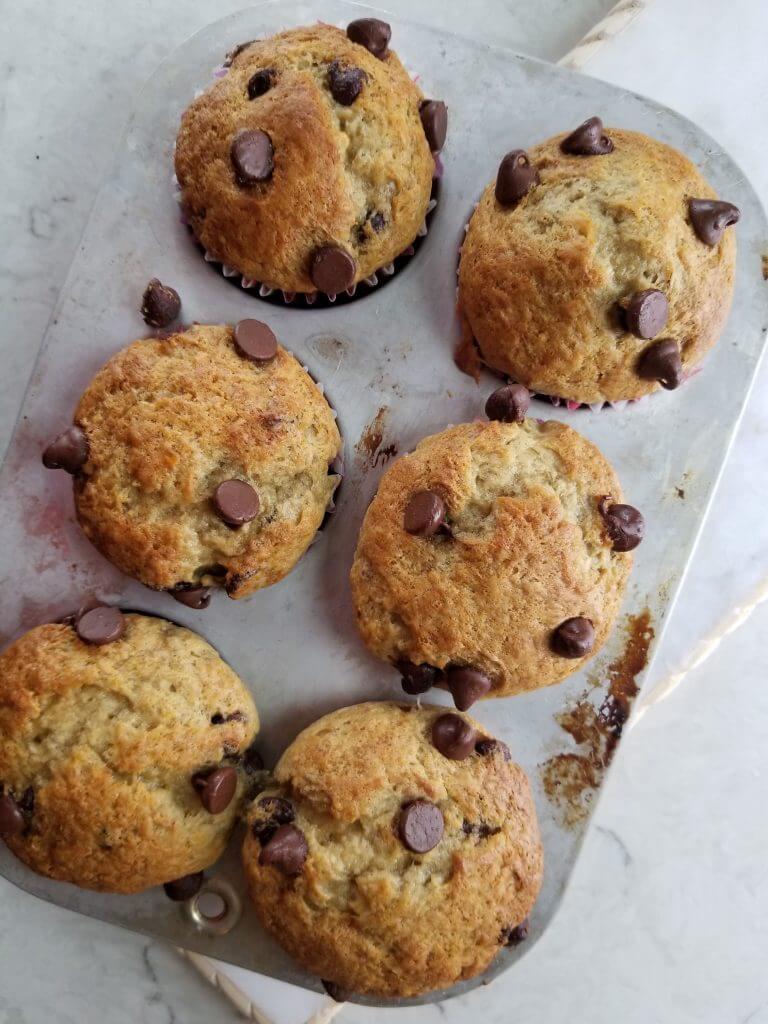 baked dairy free banana chocolate chip muffins in a muffin tin