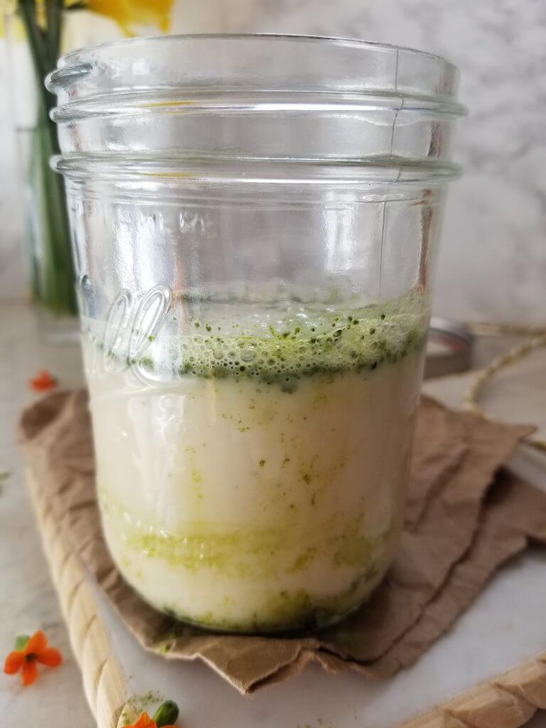 matcha green tea powder, maple syrup, and milk in a mason jar 