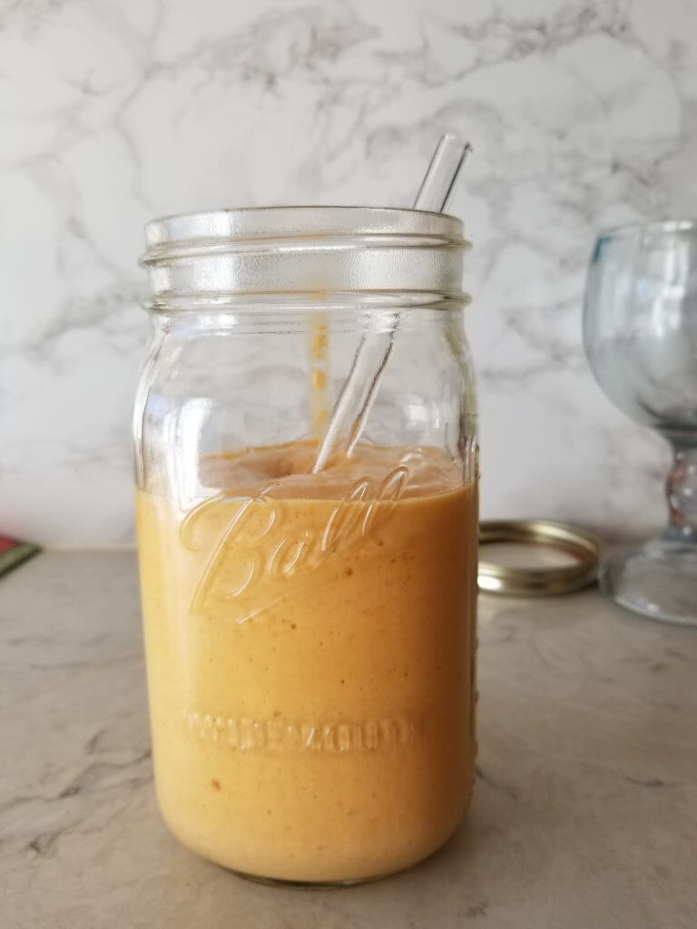 healthy carrot orange protein smoothie in a mason jar 