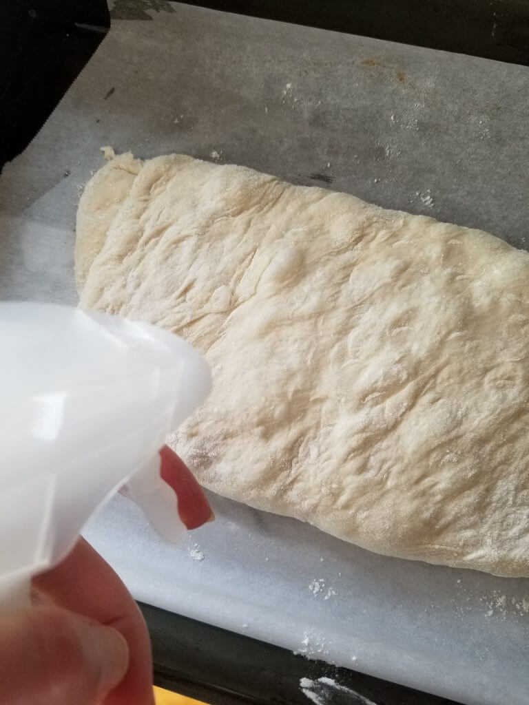 spraying ciabatta bread with water