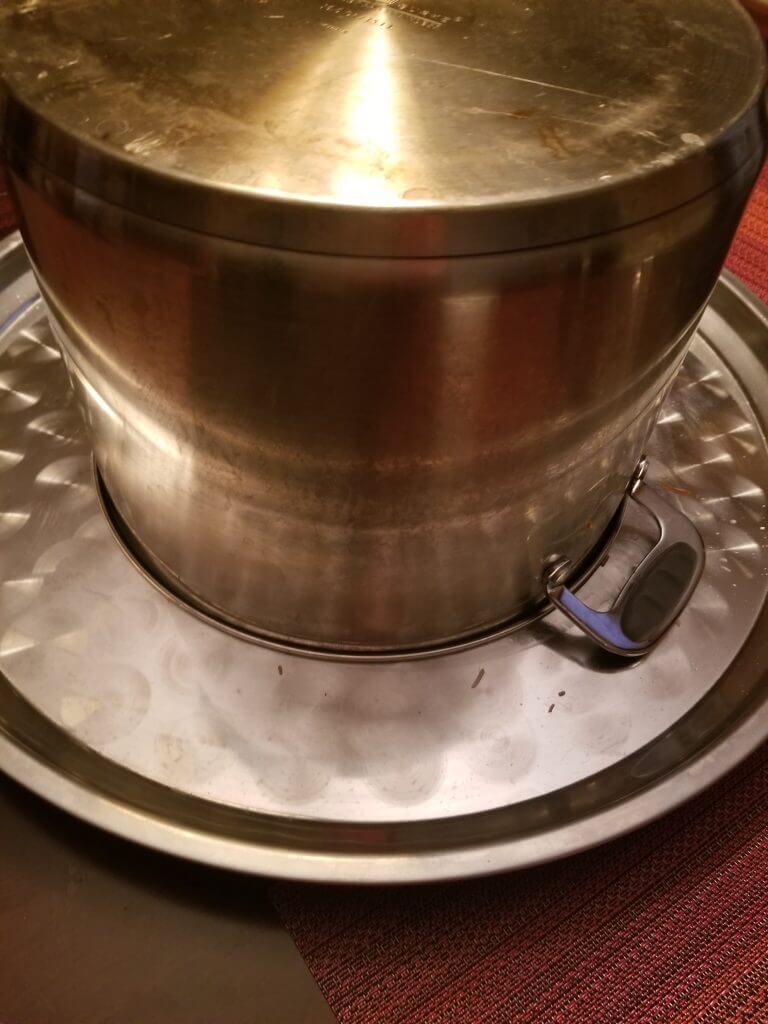 pot upside down on a metal serving tray to serve the maqluba