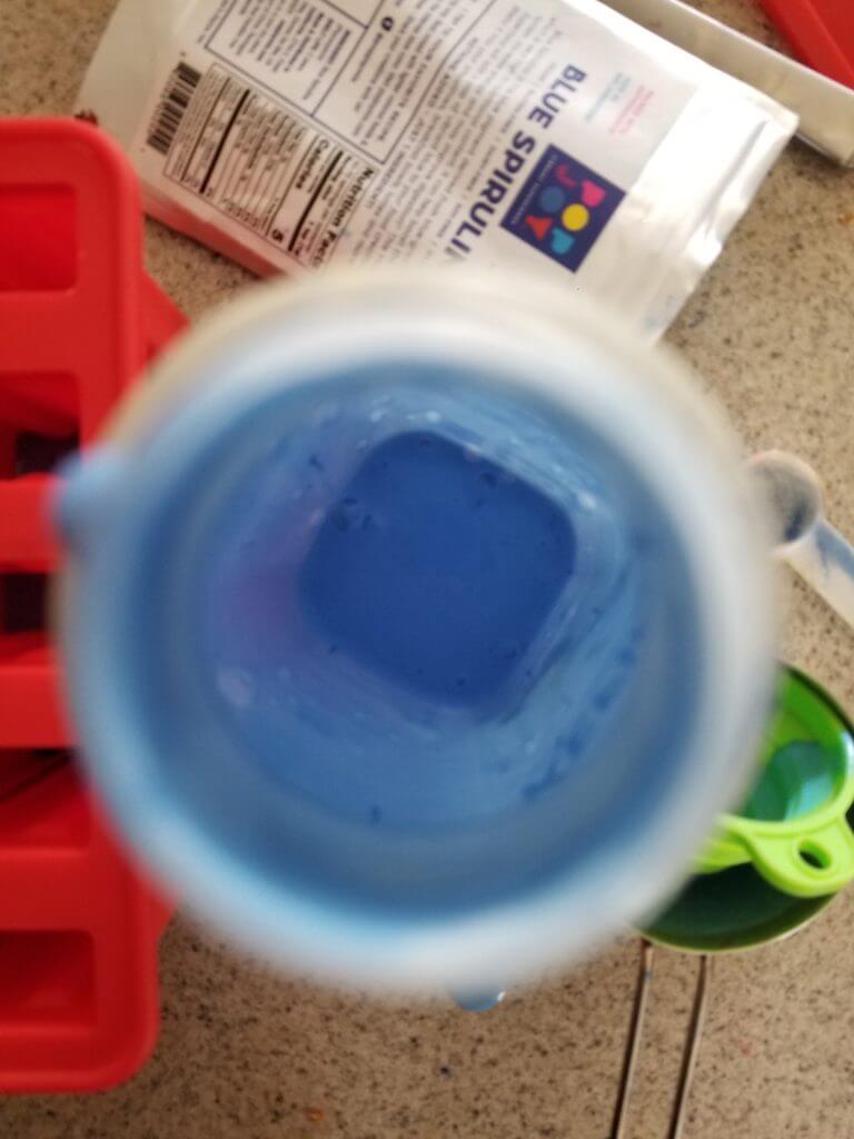 mixing blue spirulina powder into the kefir
