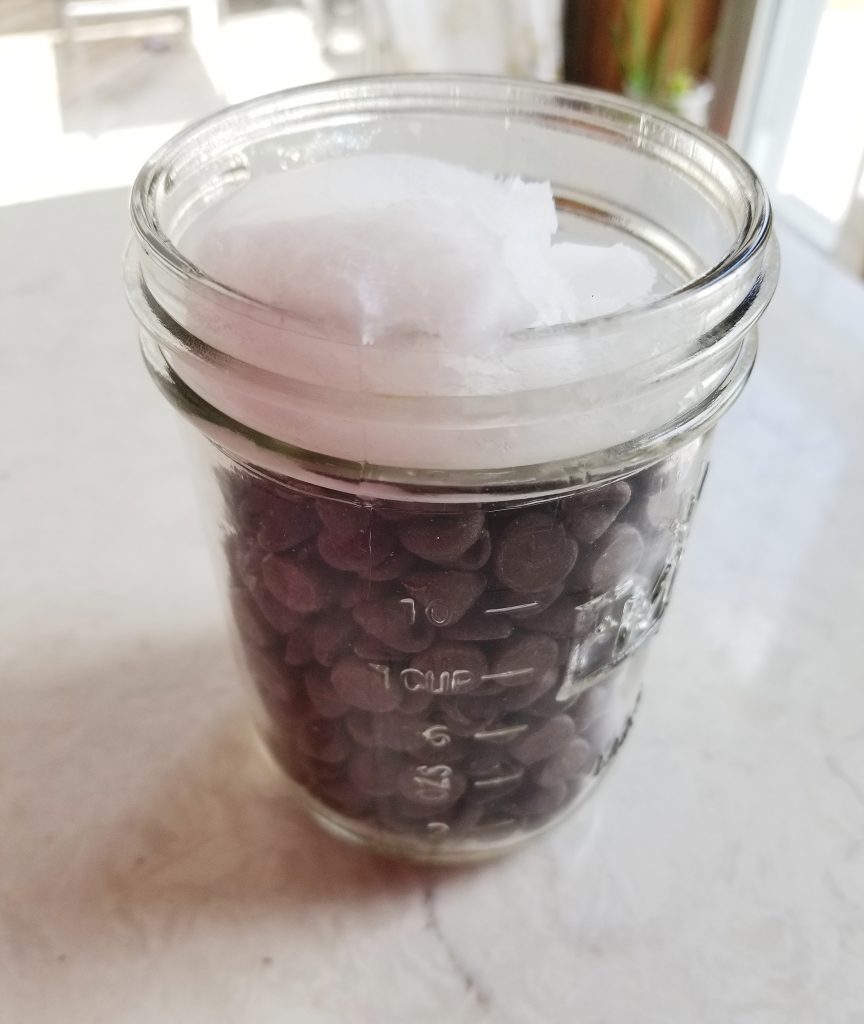 dark chocolate chips and coconut oil in a mason jar 